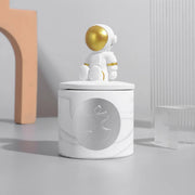 bougie en pot avec figurine astronaute assis